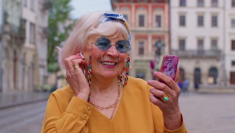 Abuela-Mayor-Turista-Con-Teléfono-Inteligente,-Sonriendo,-Escuchando-Música-En-La-Aplicación-Usando-Auriculares