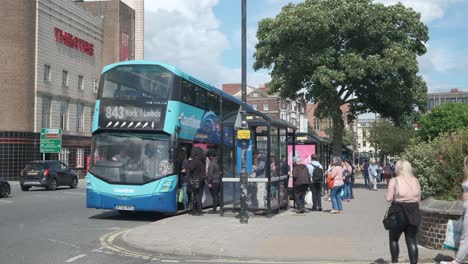 footage-of-Scarborough,-North-Yorkshire-on-a-summer-day-on-a-busy-weekend-with-families-getting-on-a-bus-to-York