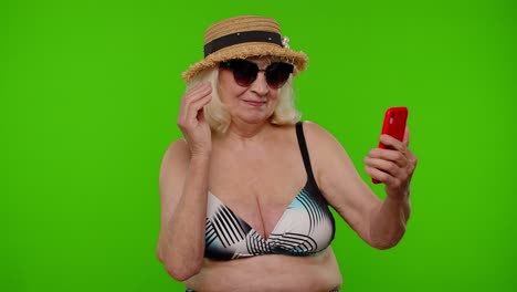 Mature-woman-traveler-blogger-in-sunglasses,-taking-selfie-portrait-photo,-video-call-on-smartphone