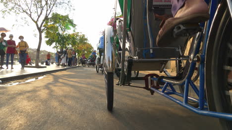 Una-Toma-Desde-Un-ángulo-Bajo-Detrás-De-Un-Taxi-De-Bicicleta-De-Tres-Ruedas-En-Hoi-An,-Vietnam.