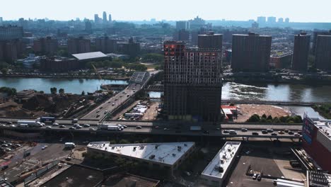 Aerial-view-of-traffic-on-Major-Deegan-Expressway,-in-sunny-Bronx,-NY,-USA---tracking,-drone-shot