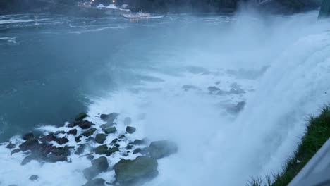 Waters-of-Niagara-Falls-flowing-down-under-the-rocks-on-a-cloudy-day,-Wide-Shot