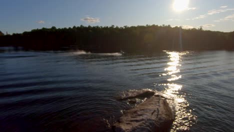 Wakeboarder-Stürzt-In-Zeitlupe,-Während-Motorboot-In-Der-Sommersonne-Auf-Blauem-See-Fährt,-Schnelle-FPV-Drohne-Luftverfolgung-In-4K