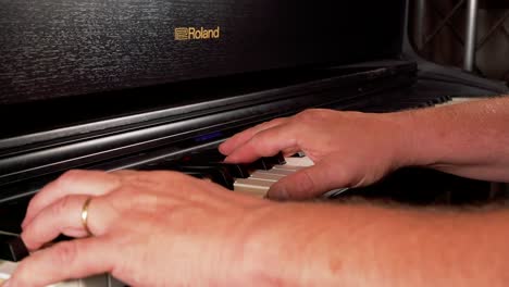 Extreme-close-up-of-married-old-man-plays-a-song-at-a-black-roland-piano