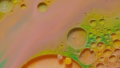 Ink-bubbles-mixed-with-liquid-substance-of-oil,-milk,-soap,-bright-acrylic-paint-on-colorful-surface