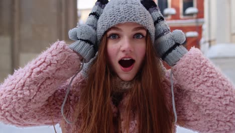 Excited-young-woman-looking-to-camera,-opening-her-mouth-in-amazement,-shouting-wow-on-city-street