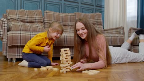 Madre-Juega-Bloques-De-Madera-Juego-De-Mesa-Con-Hija-Pequeña-Niña-En-Casa,-Pasatiempos-De-Ocio