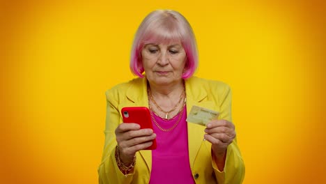 Senior-old-stylish-granny-woman-using-credit-bank-card-and-smartphone-purchases-online-shopping