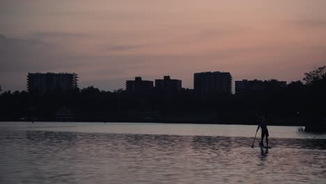 Silhouette-Of-A-Man-Paddleboarding-At-The-Lake-Of-Nations-In-Sherbrooke,-Quebec,-Canada-At-Sunset-Time---wide-shot