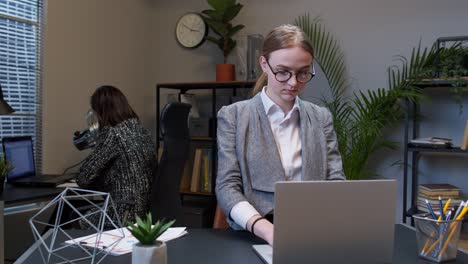 Young-business-woman-freelancer-concentrated-developing-new-project-while-looking-on-laptop-screen