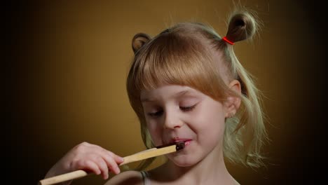 Niña-Sonriente-Alegre-Con-La-Cara-Sucia-De-Chocolate-Derretido-Sobre-Fondo-Oscuro-En-El-Estudio