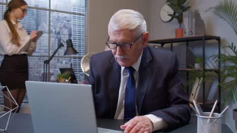 Senior-old-business-man-showing-aggressive-upset-emotion-after-unsuccessful-online-deal-with-client