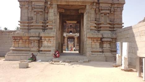 Toma-Rápida-De-Seguimiento-A-Través-De-La-Entrada-Del-Templo-En-Ruinas-En-Hampi,-Karnataka,-India