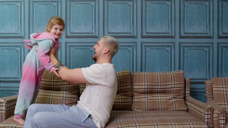 Child-girl-playing-game-laughing-having-fun-with-father,-happy-dad-lifting-small-kid-daughter-up