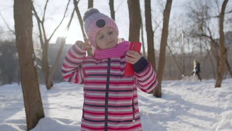 Kleine-Bloggerin-Macht-Videoanrufe-Mit-Dem-Handy,-Selfie-Foto-Für-Soziale-Netzwerke-Im-Winterpark