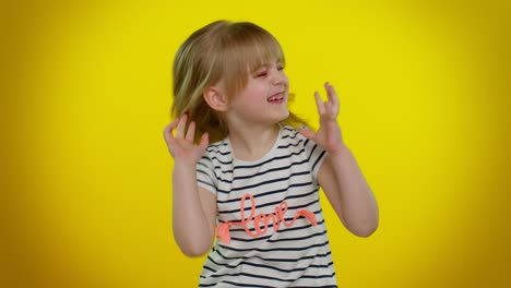 Funny-child-girl-in-striped-t-shirt-listening-music,-smiling-dancing-to-disco-music,-having-fun