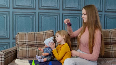 Mutter-Kümmert-Sich-Um-Tochter,-Mädchen-Bürstet-Haare-Im-Wohnzimmer,-Kind-Spielt-Mit-Spielzeugpuppe