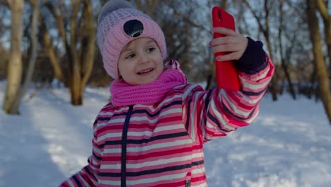 Children-kid-blogger-waving-hello,-making-video-call,-online-stream-on-social-media-in-winter-park