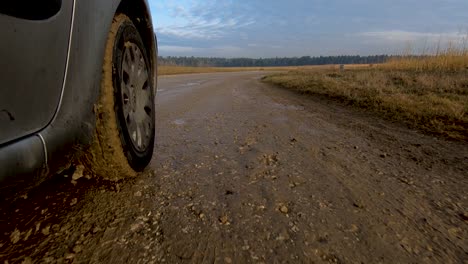 Slow-motion-low-angle-forward-dolly-moving-in-Citroen-Xsara-Picasso-car-on-countryside-macadam-road-on-bright-sunny-day