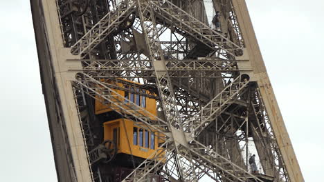 Distante-view,-Silhouettes-of-tourists-and-visitors-using-the-stairs-of-the-Eiffel-Tower,-elevator-on-the-way-down