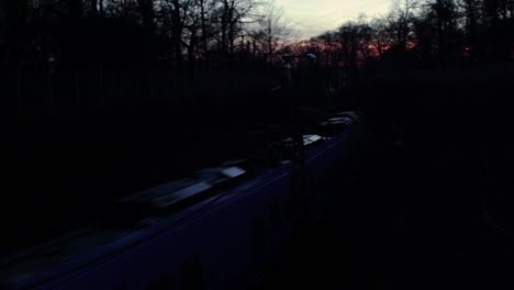 Train-passing-through-the-forest-reserve-"Pålsjö-skog"-in-Helsingborg,-Sweden-after-sunset-a-late-autumn-evening