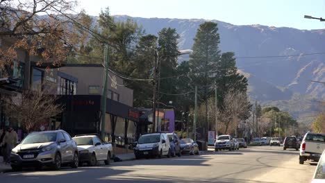 Vista-De-La-Avenida-Del-Sol-Con-Autos-Pasando-Y-Las-Montañas-Comechingones-Detrás-En-Un-Día-Soleado