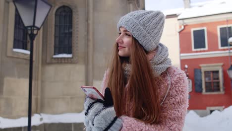 Young-traveler-woman-walking-along-old-city-holding-mobile-phone,-chatting-with-friends-and-family