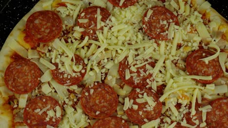 Rotating-shot-of-an-uncooked-pepperoni-pizza-on-a-tray