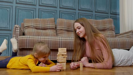 Madre-Juega-Bloques-De-Madera-Juego-De-Mesa-Con-Hija-Pequeña-Niña-En-Casa,-Pasatiempos-De-Ocio