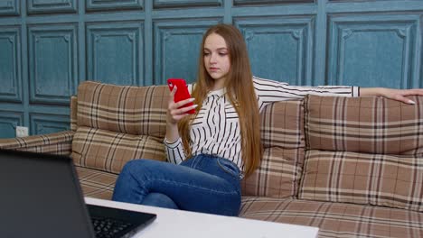 Happy-relaxed-young-woman-holding-smart-phone-looking-at-cellphone-screen-enjoying-using-mobile-apps