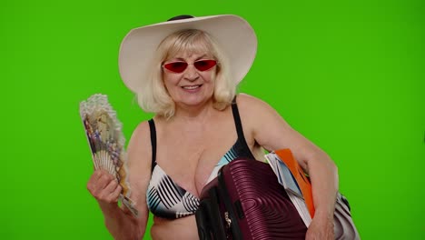 Senior-old-woman-tourist-exhales-from-heat-or-stuffiness,-waves-hand-fan-at-herself-on-chroma-key