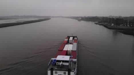 Toma-Aérea-De-Un-Barco-Portacontenedores-En-El-Río-Noord-En-Un-Día-Sombrío