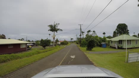 Car-driving-in-Hawaii-past-small-houses-in-residential-neighborhood