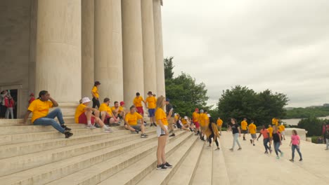 Looking-up-at-Jefferson-memorial-exterior-marble-portico,-circular-columns-and-pan-down-to-steps-and-tourists,-Washington-D