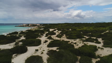 Luftaufnahme-Eines-Strandes-Mit-Weißem-Sand-Und-Vielen-Büschen,-Bewölkter-Tag,-Mallorca,-Spanien,-4k