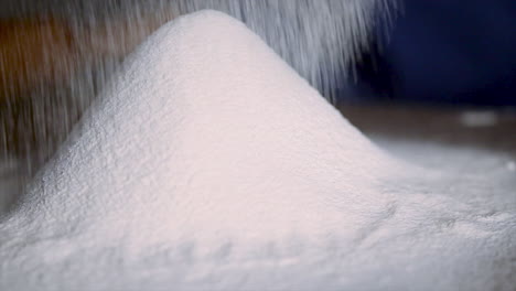 Sieving-wheat-flour-for-preparation-of-dough-on-kitchen-table