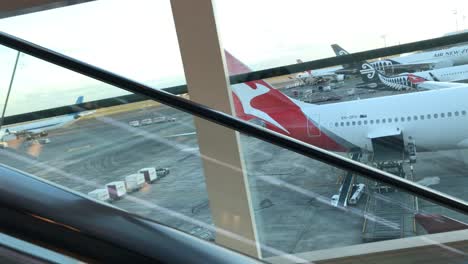 Aviones-De-Qantas-Y-Air-New-Zealand-Aterrizaron-En-El-Aeropuerto-De-Auckland,-Vistos-Desde-Una-Escalera-Mecánica-Ascendente-En-El-Aeropuerto-Internacional-De-Auckland