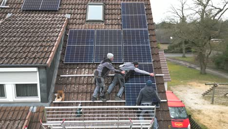 Arbeiter-Montieren-Solarmodule-Auf-Dem-Dach-Eines-Einfamilienhauses