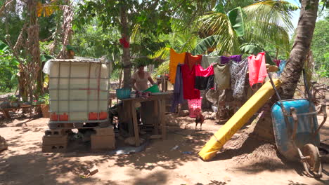 Una-Mujer-Se-Prepara-Para-Lavar-Ropa-Afuera-De-Su-Casa-En-Un-Pueblo-De-Honduras.