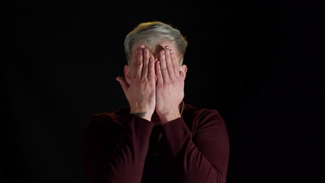 Frightened-stylish-man-looking-camera-with-scared-fearful-glance-covered-face-with-hands-hiding