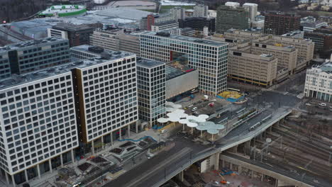 Toma-Aérea,-Seguimiento,-Toma-Panorámica-Con-Dron-Alrededor-Del-Centro-Comercial-Tripla-Y-La-Estación-De-Tren-De-Pasila,-En-Una-Tarde-Parcialmente-Soleada,-En-Helsinki,-Finlandia