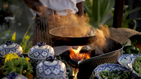 Slow-Motion,-Summer-Frying-Pan-Tossing-Food,-Sunset-Shine-Through-Smoke