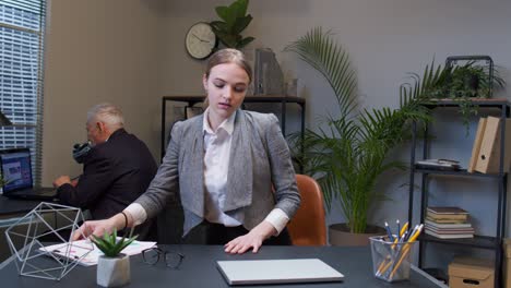 Businesswoman-freelancer-in-office-walking-and-sit-at-workplace-with-laptop-computer,-start-working