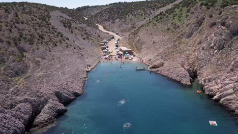 Tiefer-Draga-Strand-Voller-Touristen,-Die-Ihren-Urlaub-In-Der-Sonne-Genießen,-Umgeben-Von-Felsen