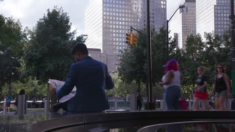 A-shot-from-behind-a-business-man-reading-the-newspaper-in-the-Financial-District,-New-York