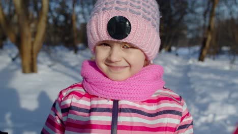 Niño-Tímido-Sonriente-Mirando-La-Cámara,-Bromeando,-Haciendo-Caras-En-El-Bosque-Nevado-De-Invierno