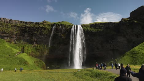 Cataratas-De-Seljalandsfoss-En-Islandia-Con-Video-De-Cardán-Que-Muestra-A-Personas-Caminando-Hacia-Adelante