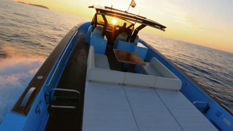 Vista-Aérea-FPV-Alrededor-De-Un-Yate-Mientras-Navega-Hacia-El-Atardecer-Frente-A-La-Costa-De-Ibiza