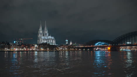 Vista-Panorámica-De-La-Catedral-De-Colonia-Por-La-Noche-Con-Bonitas-Luces-Y-Agua-Alta