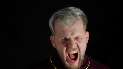 Disappointed-handsome-man-in-stylish-blouse-agressive-emotion,-shouting-at-loud-on-black-background